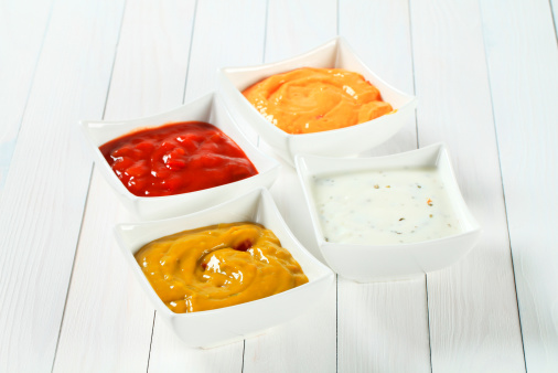 various salsa dips in white square bowls