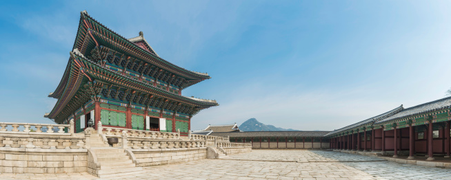 The ornately painted eaves and traditional wooden screens of Geunjeongjeon, Throne Hall of the Joseon Dynasty kings, overlooking the stone courtyard of Gyeongbokgung palace in the historic heart of Seoul, South Korea. ProPhoto RGB profile for maximum color fidelity and gamut.