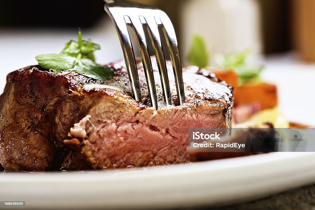 Macio e suculento, um garfo pierces Filé de carne bovina grelhado - Foto de stock de Bife royalty-free