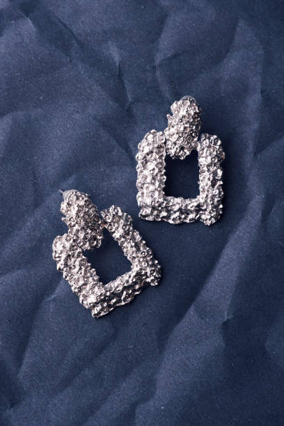 istock silver earrings jewelry on a paper background close-up 1686355982