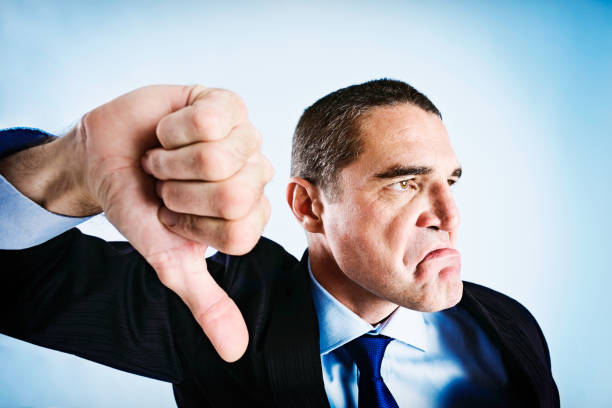 istock Angrily frowning businessman makes thumbs-down signal 168635685