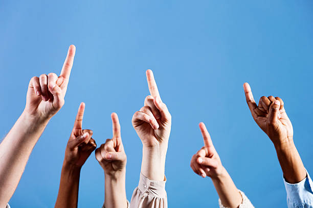 istock Reach for the sky! Six hands point up into blue 168635805