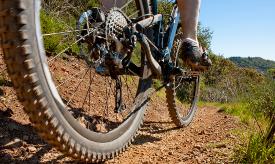 A ground level view of a mountain bike on a trail during a bright sunny day in northern California.