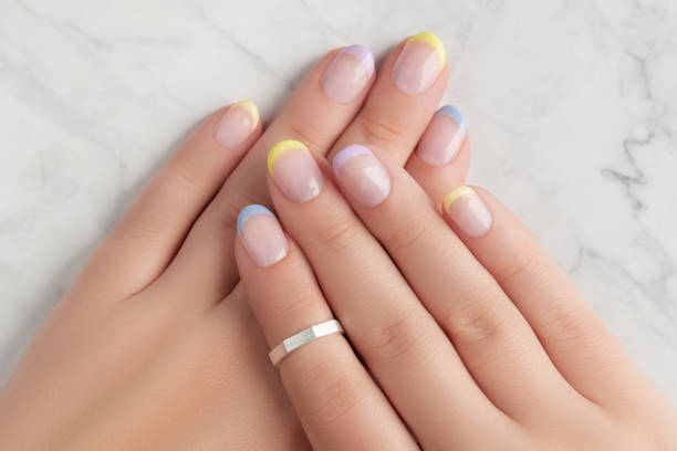 istock Beautiful womans hands with spring summer nail design on marble gray background 1686368737