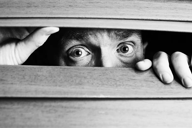 homem preocupado peeping) com venezianas de madeira cega - paranoia terrified men horror - fotografias e filmes do acervo