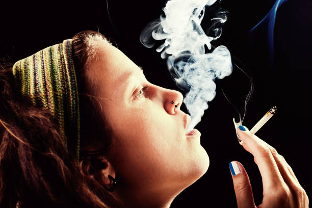 istock Dreadlocked young woman smoking cannabis 168637810