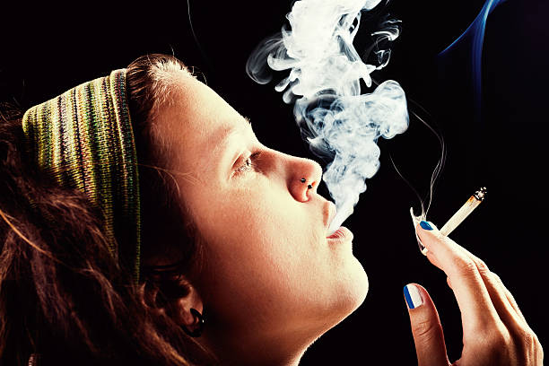 dreadlocked młoda kobieta palenie cannabis - handroll zdjęcia i obrazy z banku zdjęć