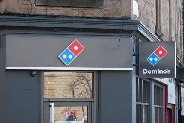 domino pizza, logo ze sklepu zewnętrznego. jest to amerykańska sieć pizzerii. - dominos pizza zdjęcia i obrazy z banku zdjęć