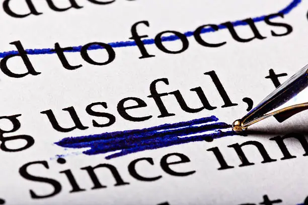 In a printed document, a fountain pen has crossed out some words and is underlining the word 'useful' heavily,  prioritizing perhaps!