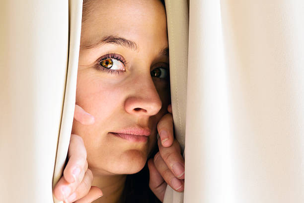 istock Beautiful blonde peeps through closed curtains 168640010