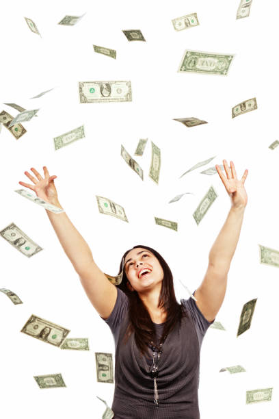 istock Delighted brunette tries to catch many falling dollars 168640148