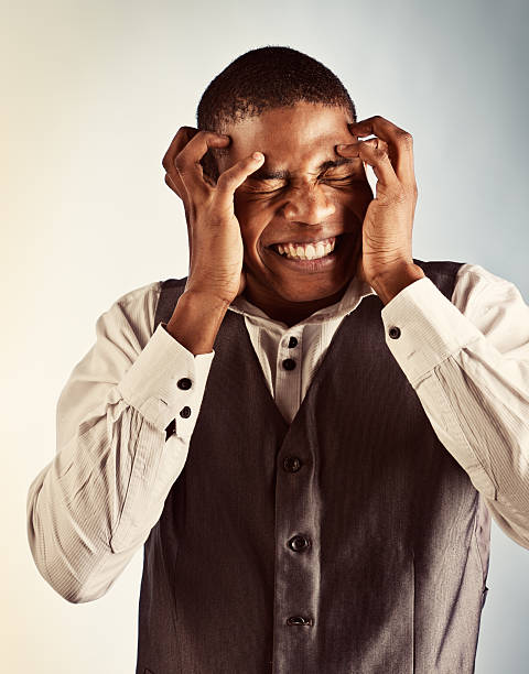 istock Splitting headache! Agonised young man clutching his head and grimacing 168640318