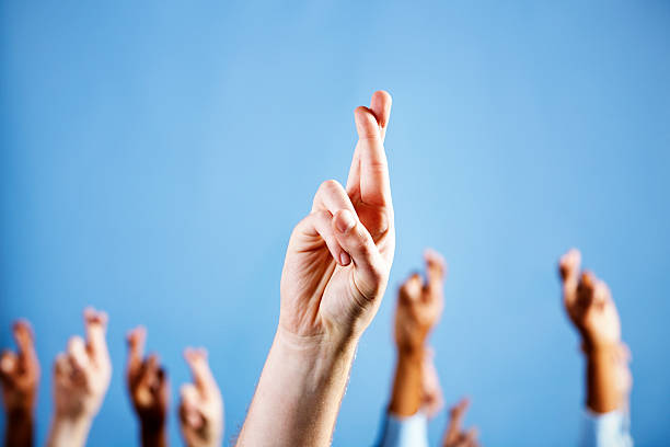 istock Man's hand with superstitiously crossed fingers, more in blue background 168640419