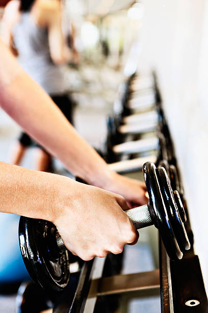 istock Female hands selecting weights from rack in a gym 168641460