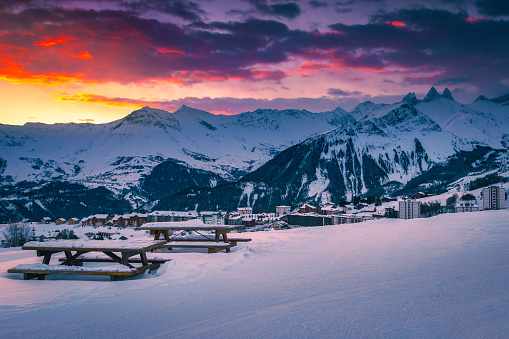 Cozy resting place with great view at sunrise. Famous ski resort view from the slope at dawn, La Toussuire, France, Europe