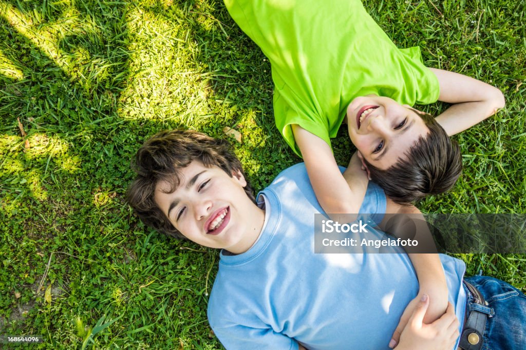 Crianças deitado para baixo na grama e sonhar, sorrindo - Foto de stock de 10-11 Anos royalty-free