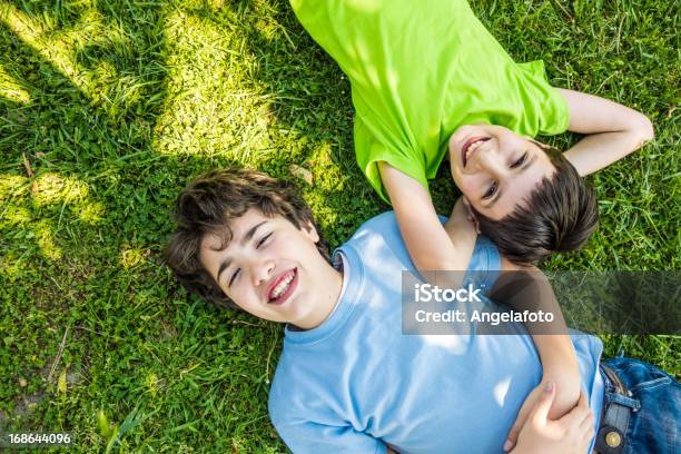 Foto de Crianças Deitado Para Baixo Na Grama E Sonhar Sorrindo e mais fotos de stock de 10-11 Anos