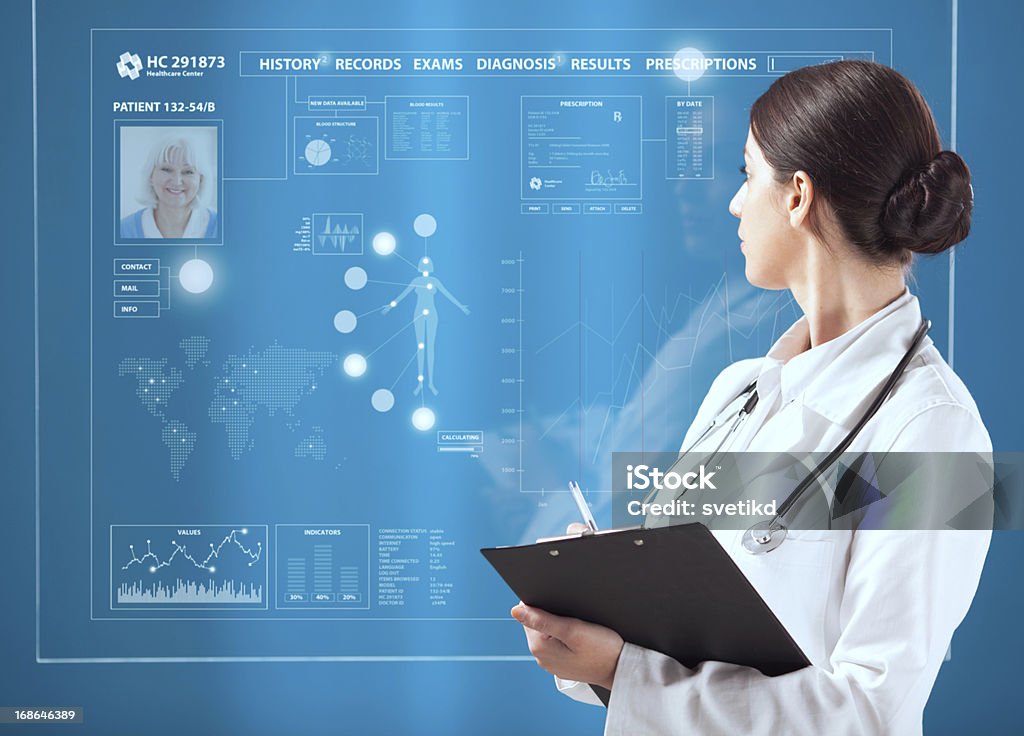 Female doctor working on transparent monitor. Female doctor working on futuristic transparent monitor on blue background.  Healthcare And Medicine Stock Photo