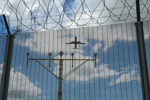 A Cathay Pacific Airbus A330-342 plane, registration B-LAB, takes off from Hong Kong International Airport, passing over navigational lights, razor wire and steel fencing and heading to Manila as flight CX919. This image was taken under the flight path for planes taking off on a hot, humid and partly cloudy afternoon on 12 September 2023.