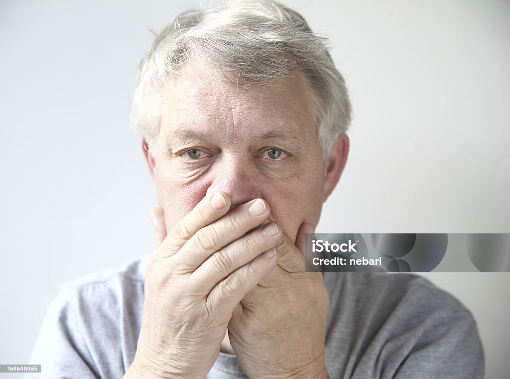 man worried about his bad breath senior man holds his hands over his mouth Bad Breath Stock Photo