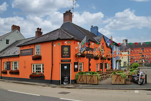 Llandovery, Carmarthenshire, Wales, UK - The Bear Inn pub painted bright orange and bedecked in flags and bunting, Kings Road