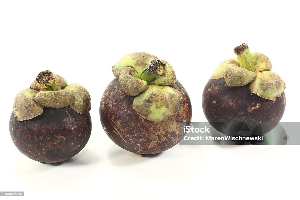 three fresh Mangosteen three fresh mangosteen fruits on a light background Anti Aging Stock Photo