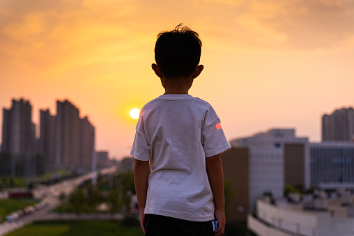 a child looking city sunset alone