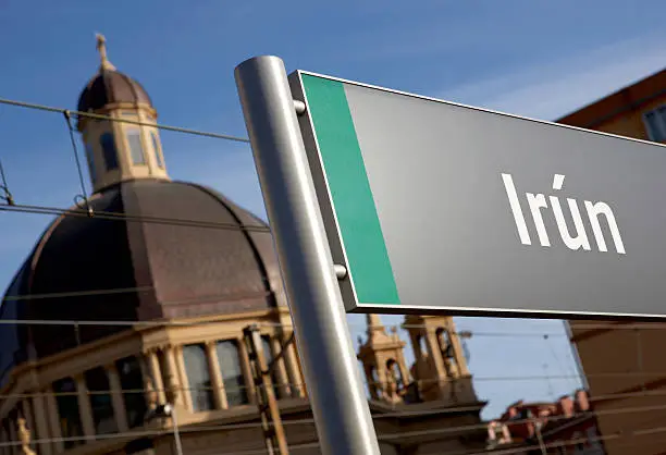 City name signpost at railway station with out of focus church on background