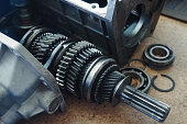 Gear spare part for car lies on workbench. Gears and transfer case. equipment repair