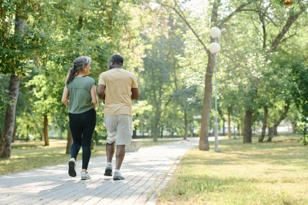 公園を走っている年配のカップル - senior adult retirement mature adult couple ストックフォトと画像