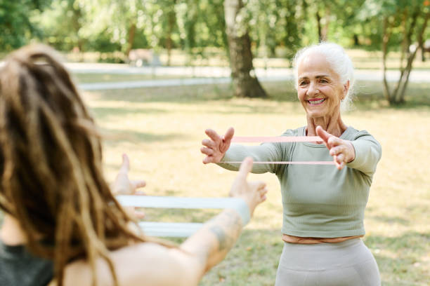 istock Senior woman training with rubber band with coach 1686540319