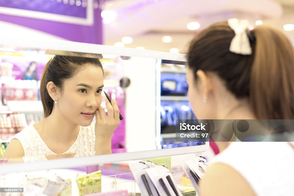 Mujer asiática de compras en la tienda de los productos cosméticos. - Foto de stock de Maquillaje libre de derechos