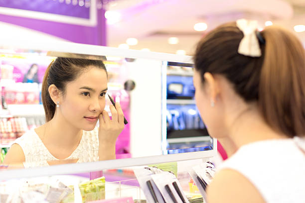 asiatique femme shopping dans le magasin d'élaborer des produits cosmétiques. - asian ethnicity women shopping mall perfume photos et images de collection