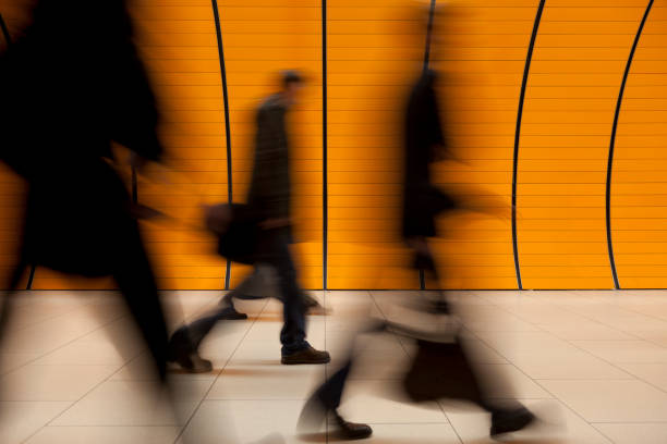 istock motion blurred commuters in front of modern orange subway tube 168658783