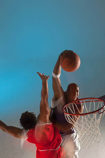 basketballspieler dunks. ball - arms outstretched arms raised studio shot adult stock-fotos und bilder