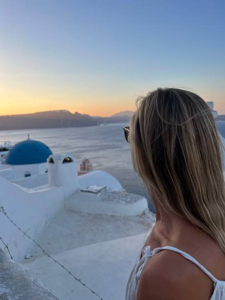 istock Woman contemplates Santorini from top, Greece 1686640164