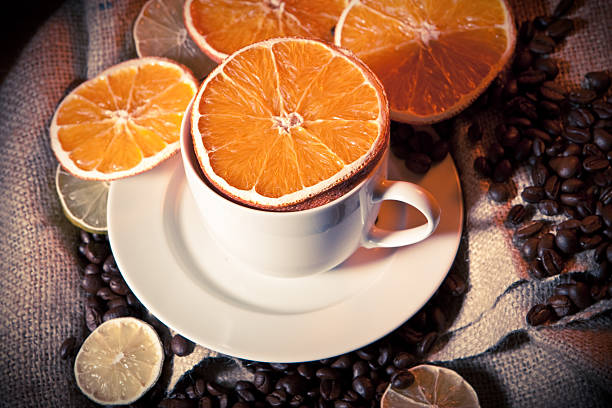 Cup with coffee beans, orange and lemon stock photo