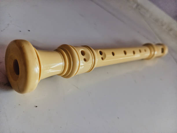 A wooden recorder resting on a sheet of music.