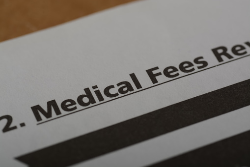 Close up view of the word MEDICAL FEES. Medical fees refer to the charges or fees that healthcare providers for their services, treatments, and medical care