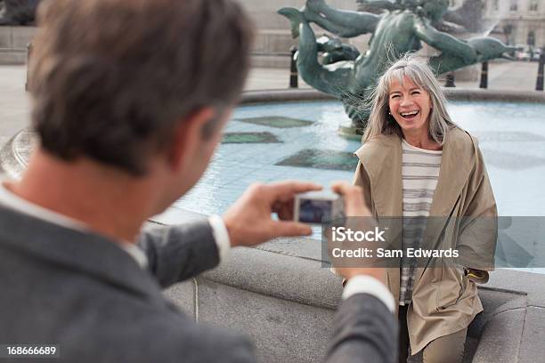 Mann Mit Digitalen Kamera Fotografieren Frau In Der Nähe Der Brunnen Stockfoto und mehr Bilder von Stadt