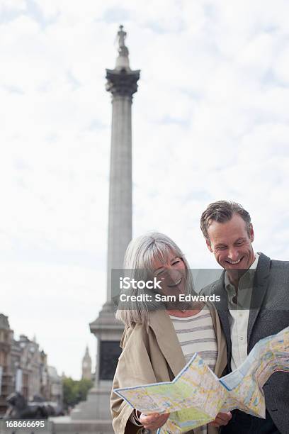 Coppia Sorridente Guardando La Mappa Nella Monument - Fotografie stock e altre immagini di Coppia di età matura