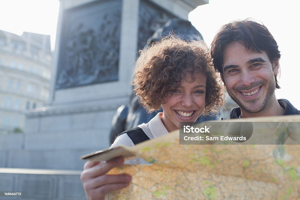 Счастливая пара с картой ниже Памятник - Стоковые фото Карта роялти-фри