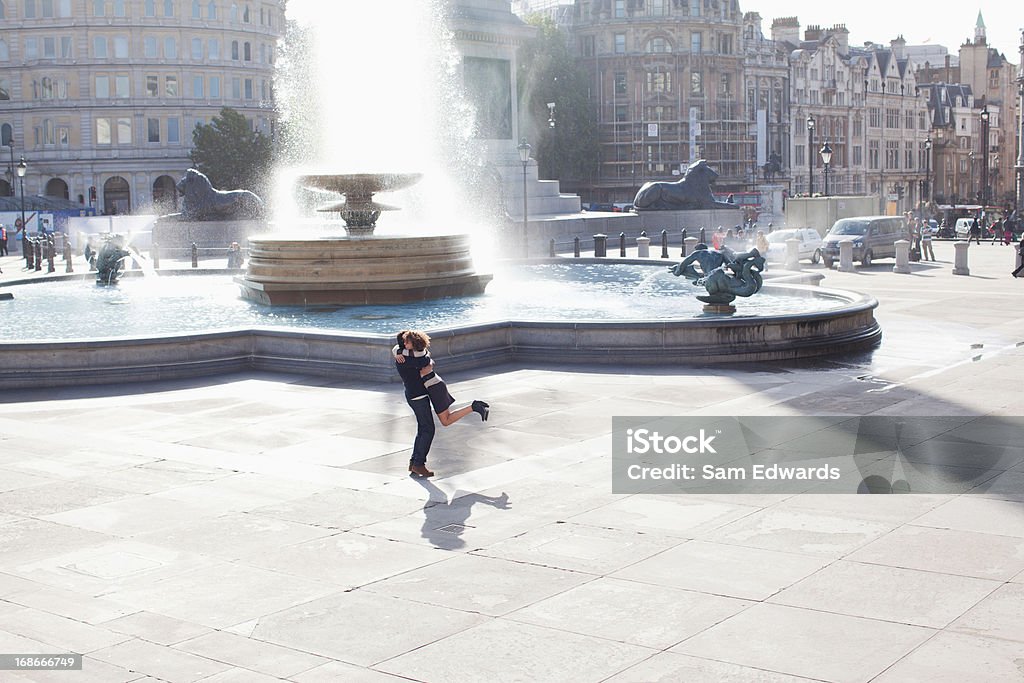 Человек, поднимая женщина перед городской фонтан - Стоковые фото Люди роялти-фри