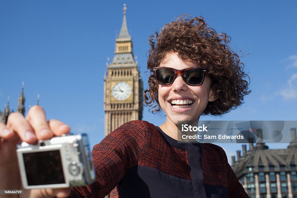 Femme souriante prenant autoportrait avec appareil photo numérique - Photo de Jeunes femmes libre de droits
