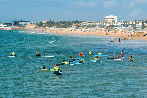 Carcavelos, Portugal - September 15, 2023: Group of young surfers at Carcavelos beach near Lisbon, Portugal during a summer day