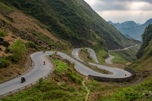 Mountain road in the neighbourhood of Yen Mink, during the so-called Ha Giang Loop in North Vietnam. Some motorbikes on the road.