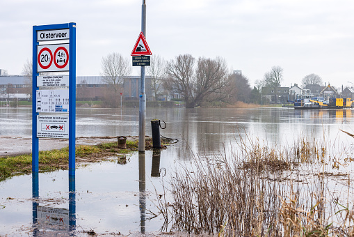 Olst Wijhe, The Netherlands - January 21, 2023: Name sign and ferry pond Olsterveer with flooded river at crossing IJssel river in Olst Wijhe Welsum in Overijssel in The Netherlands