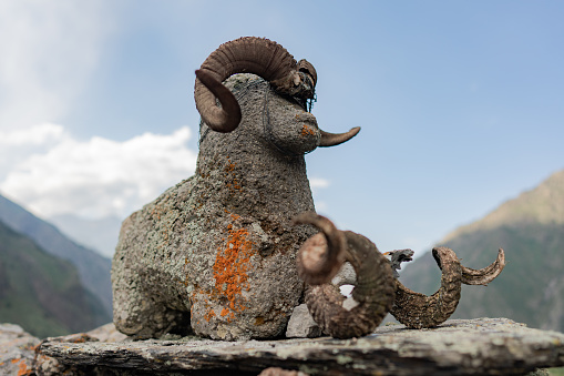 Statue of sheep with added real horns in the mountains