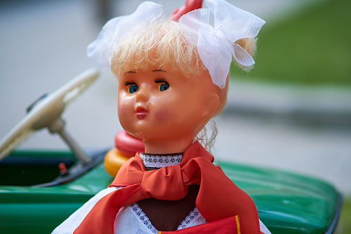 A close up shot of an antique doll's head showing the discolouration and cracks on her face.  But she has such a serene expression.