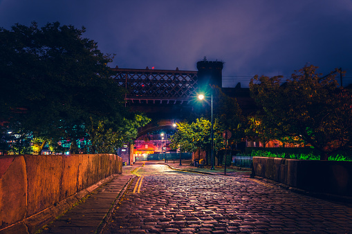 Dark and gloomy industrial atmosphere under the historical rail bridges in Manchester